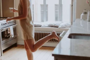 femme en pyjama devant radiateur
