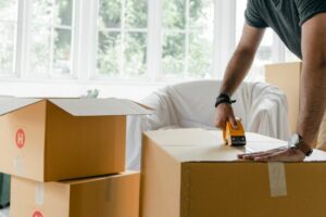 homme en train de fermer cartons